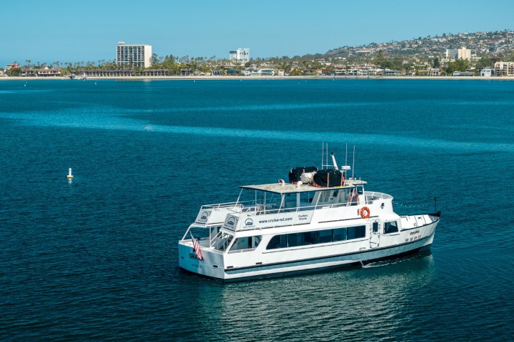 a large ship in a body of water with a city in the background