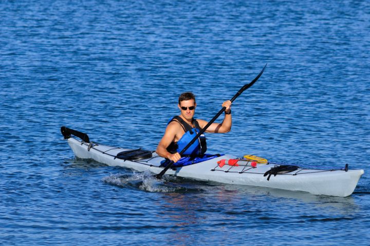 a man riding a surf board on a body of water