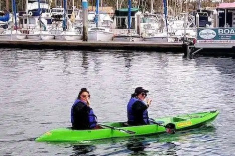 a group of people riding on the back of a boat in the water