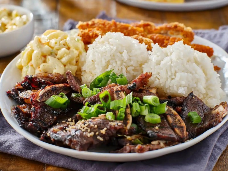 a plate of food with rice meat and vegetables