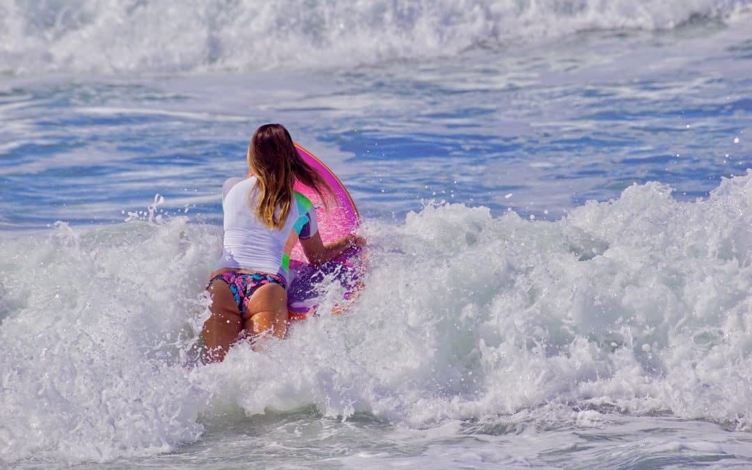 Things-to-Do-in-San-Diego-10022022-1080×675 a young girl riding a wave on a surfboard in the ocean