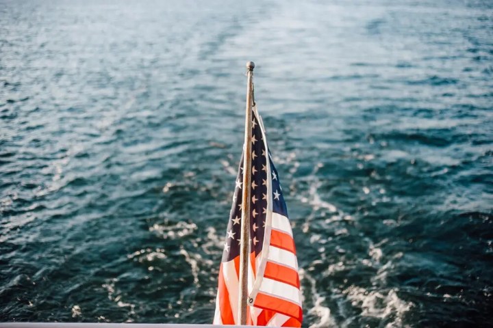 American flag on boat with water in the background.